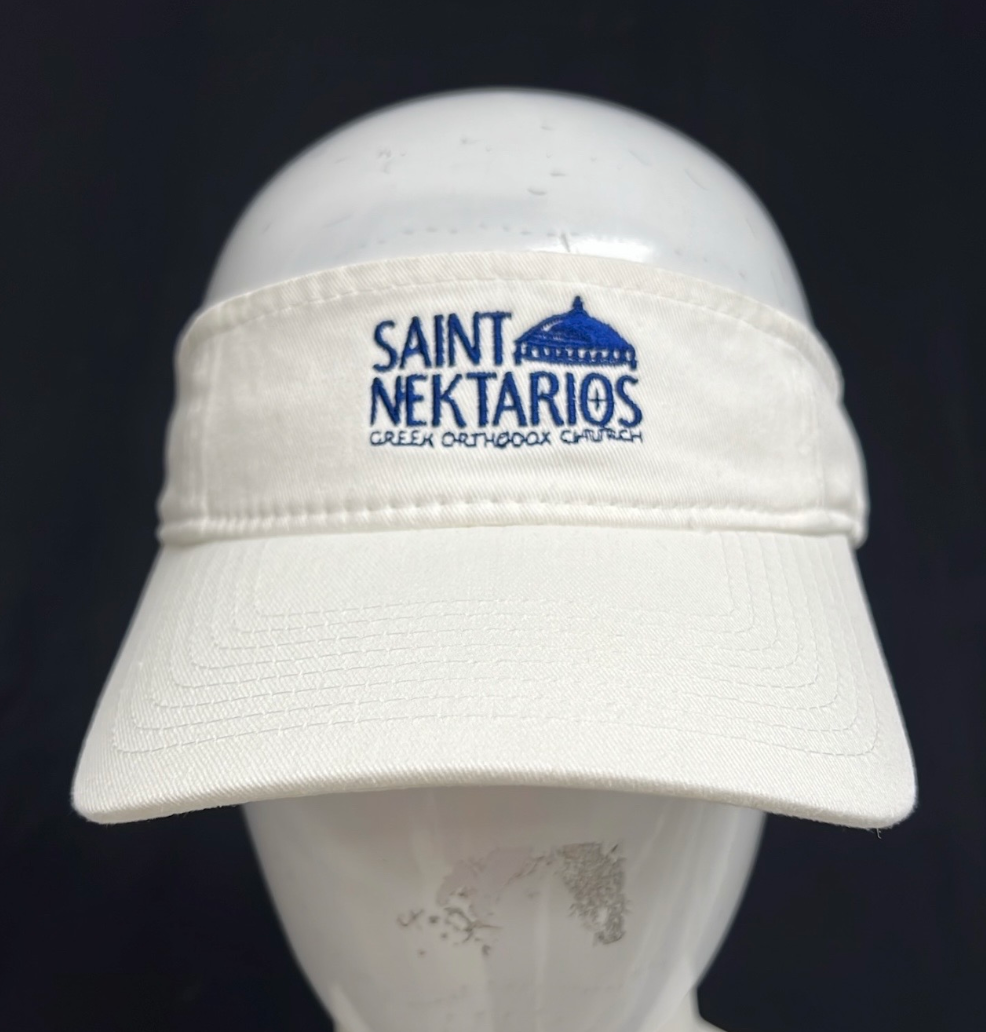 White visor cap embroidered with blue text reading 'Saint Nektarios Greek Orthodox Church' and a dome graphic above the text.