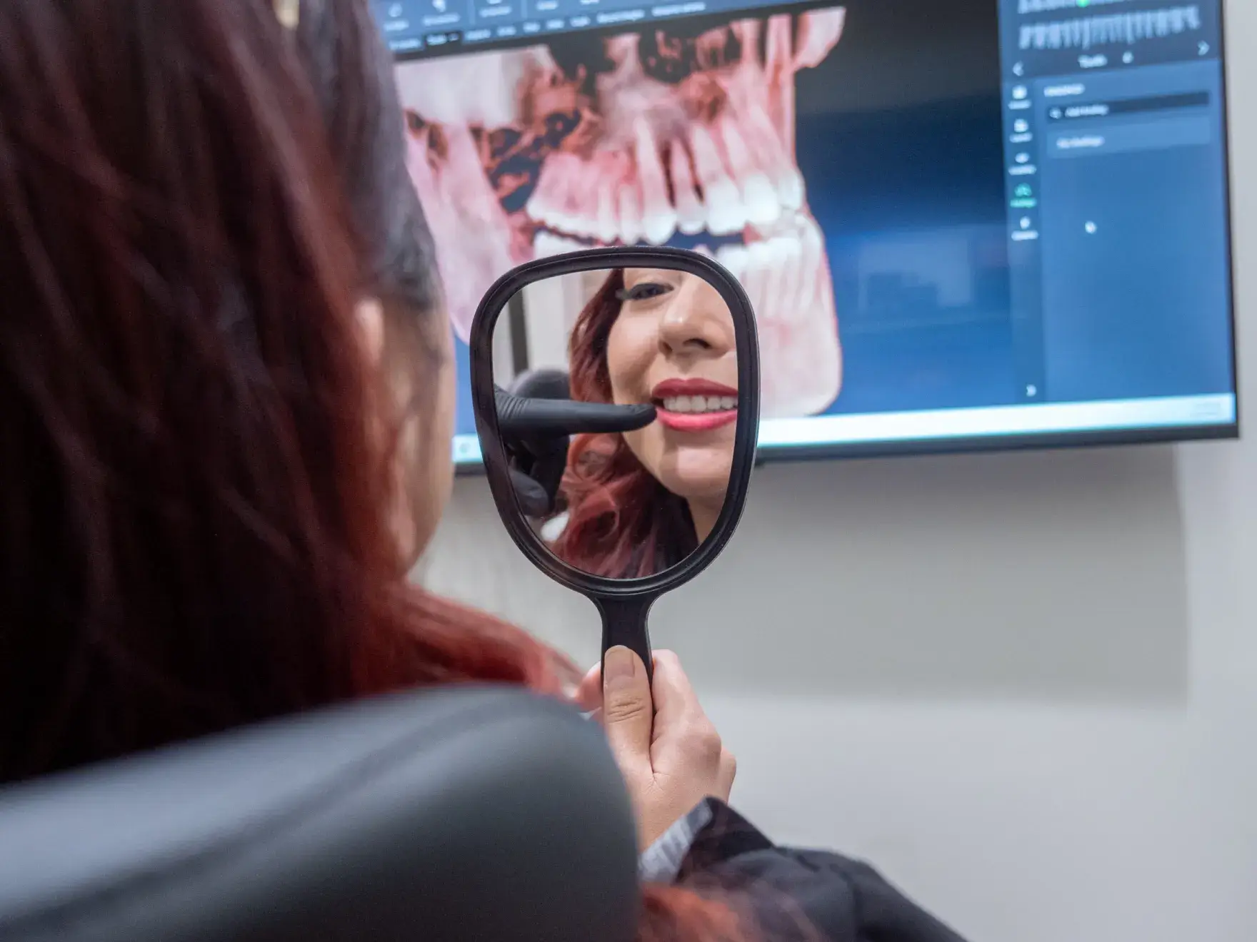 A dentist wearing magnifying glasses is preparing dental tools in a clinic.