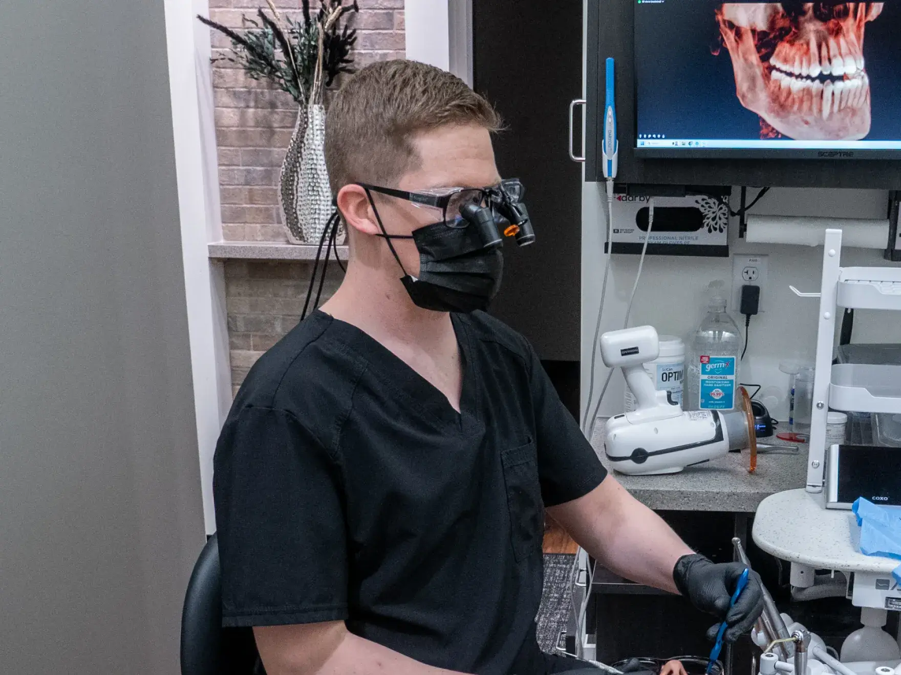 A dentist and patient shake hands and smile in a dental office.