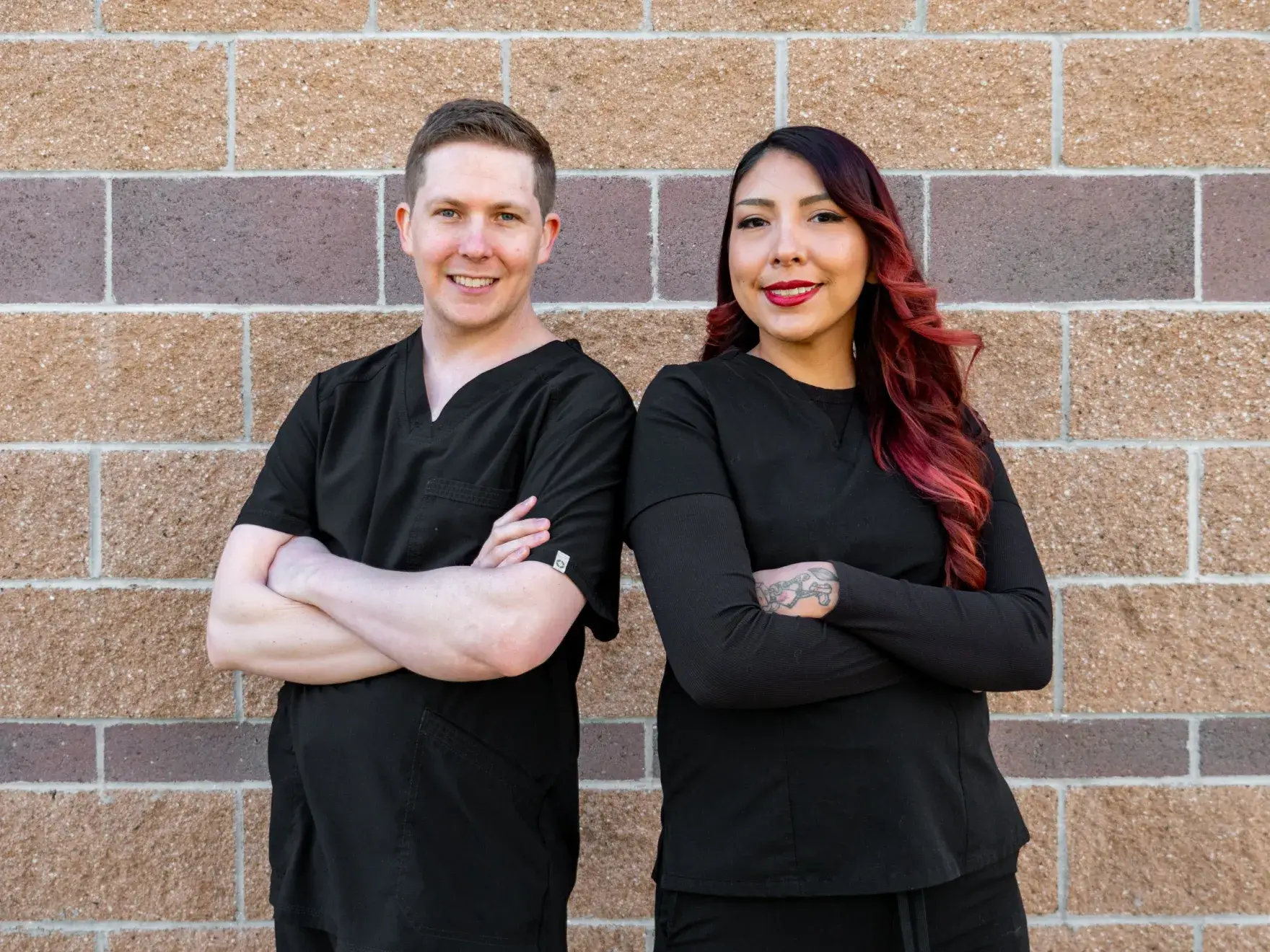 A dental veneer being held by tweezers in a dental office setting.