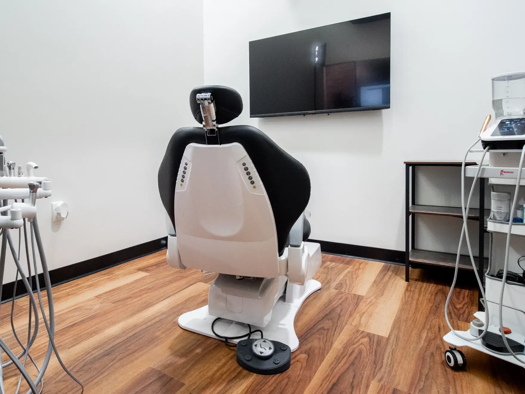 A person points at a dental X-ray on a screen during a presentation to another individual.