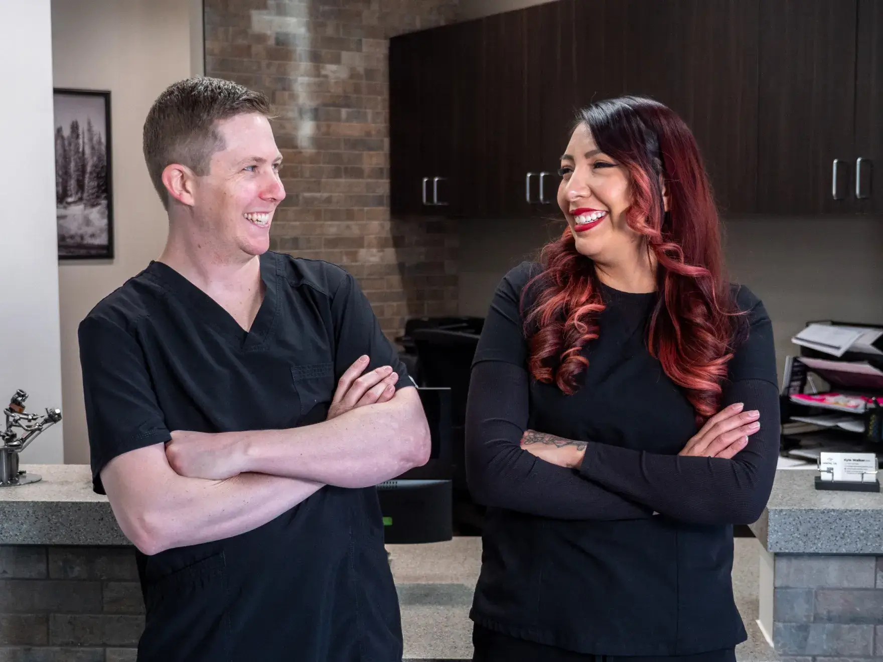A person in medical scrubs and gloves wearing magnifying glasses, preparing to perform a task.