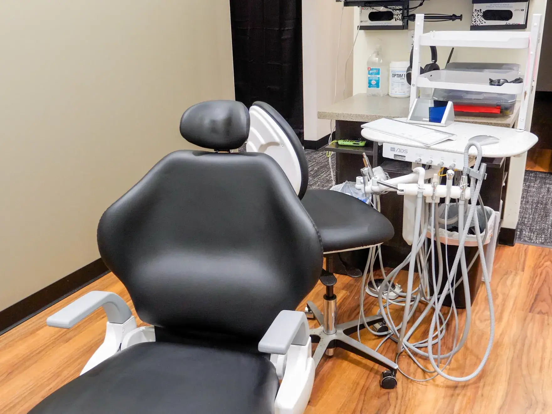 A dentist and a patient shaking hands in a dental office.