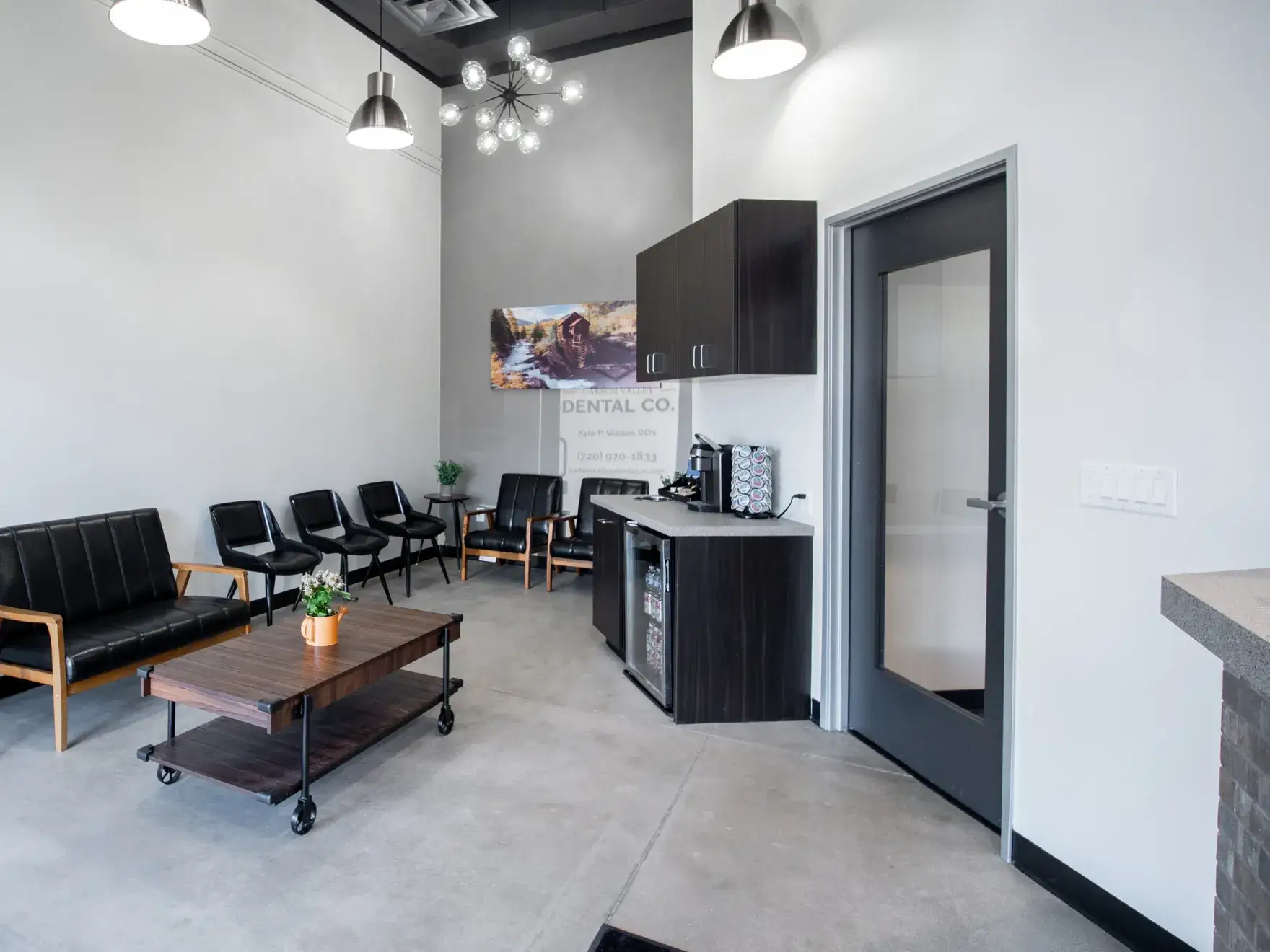 A dentist explains dental X-rays on a screen to a patient sitting nearby.