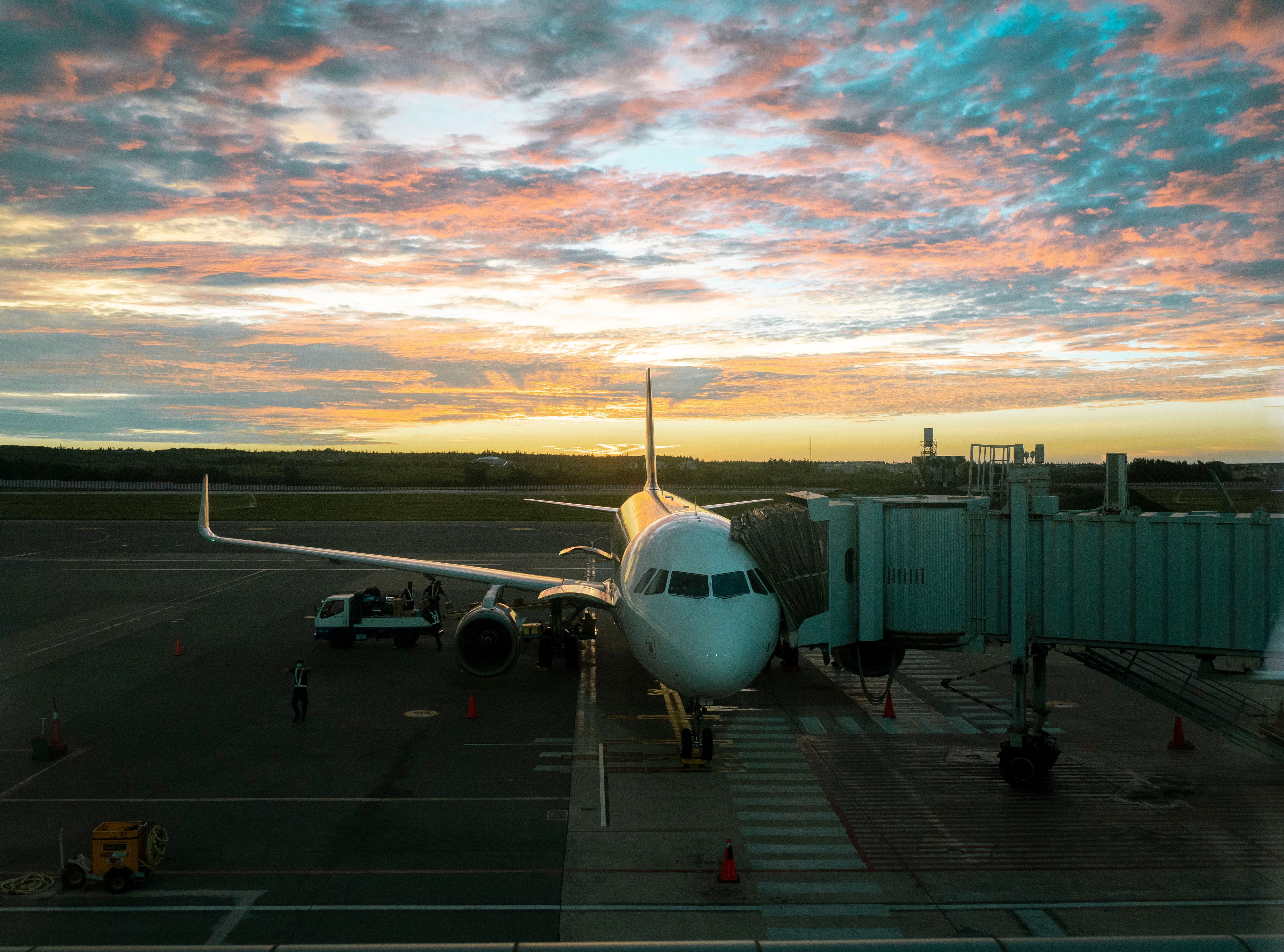 A passenger aircraft at the gate at sunset