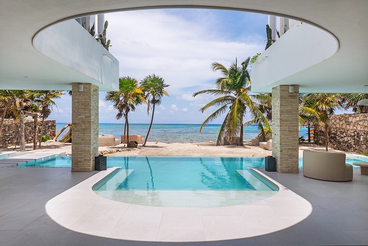 Circular pool framed by palms looking out to the Caribbean at Soliman Bay