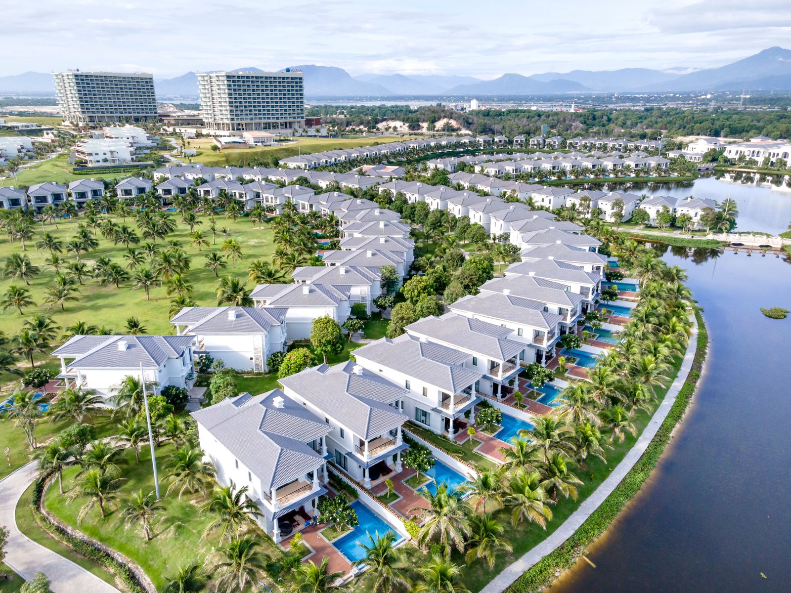 Aerial view of a low rise resort complex laid out along a lagoon