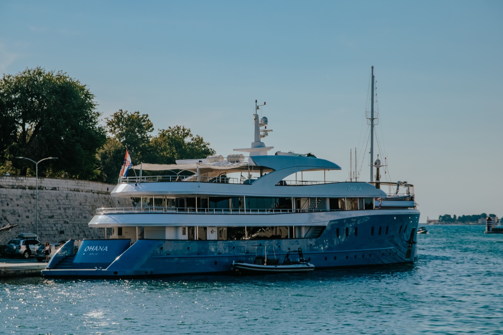 A large motor yacht berthed alongside a dock in calm tropical water