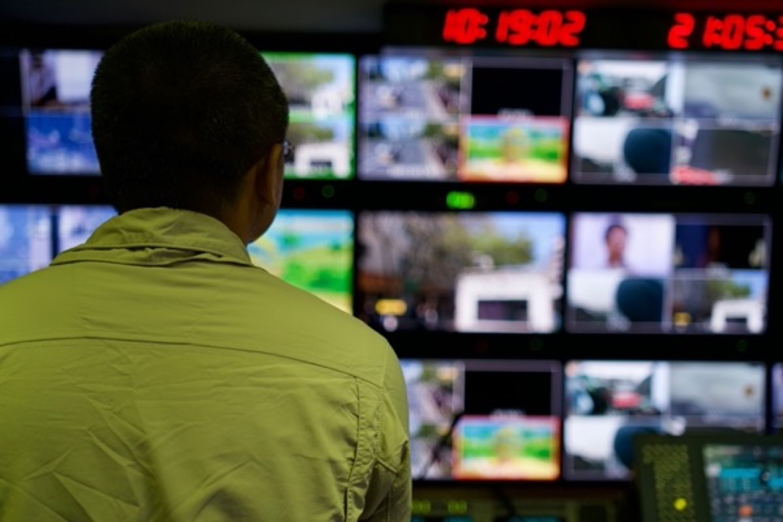 An operator in front of a wall of live camera feeds in a monitoring room