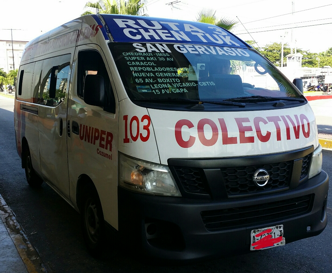 A white Nissan colectivo van with COLECTIVO in red letters across the front and its route listed on the windshield