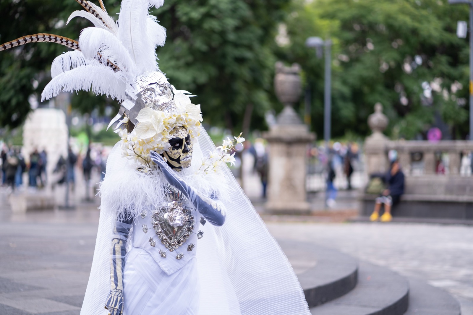 A Catrina in an elaborate white Day of the Dead costume in a Mexican city plaza