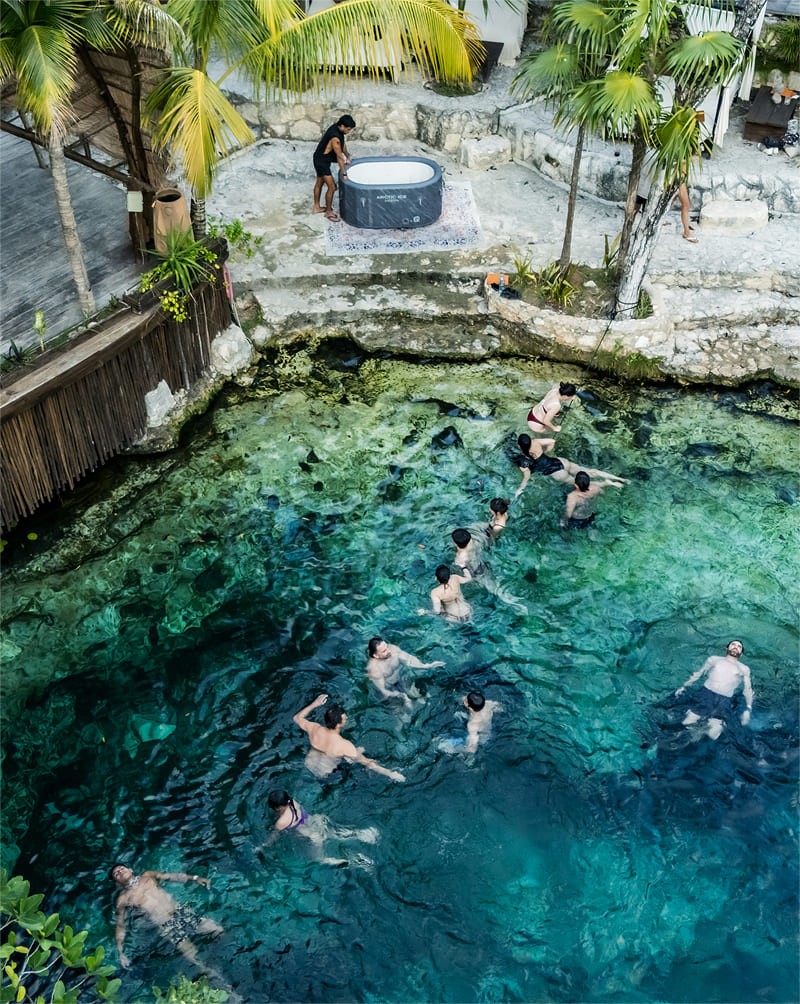 Swimmers in the turquoise water of the cenote, seen from above