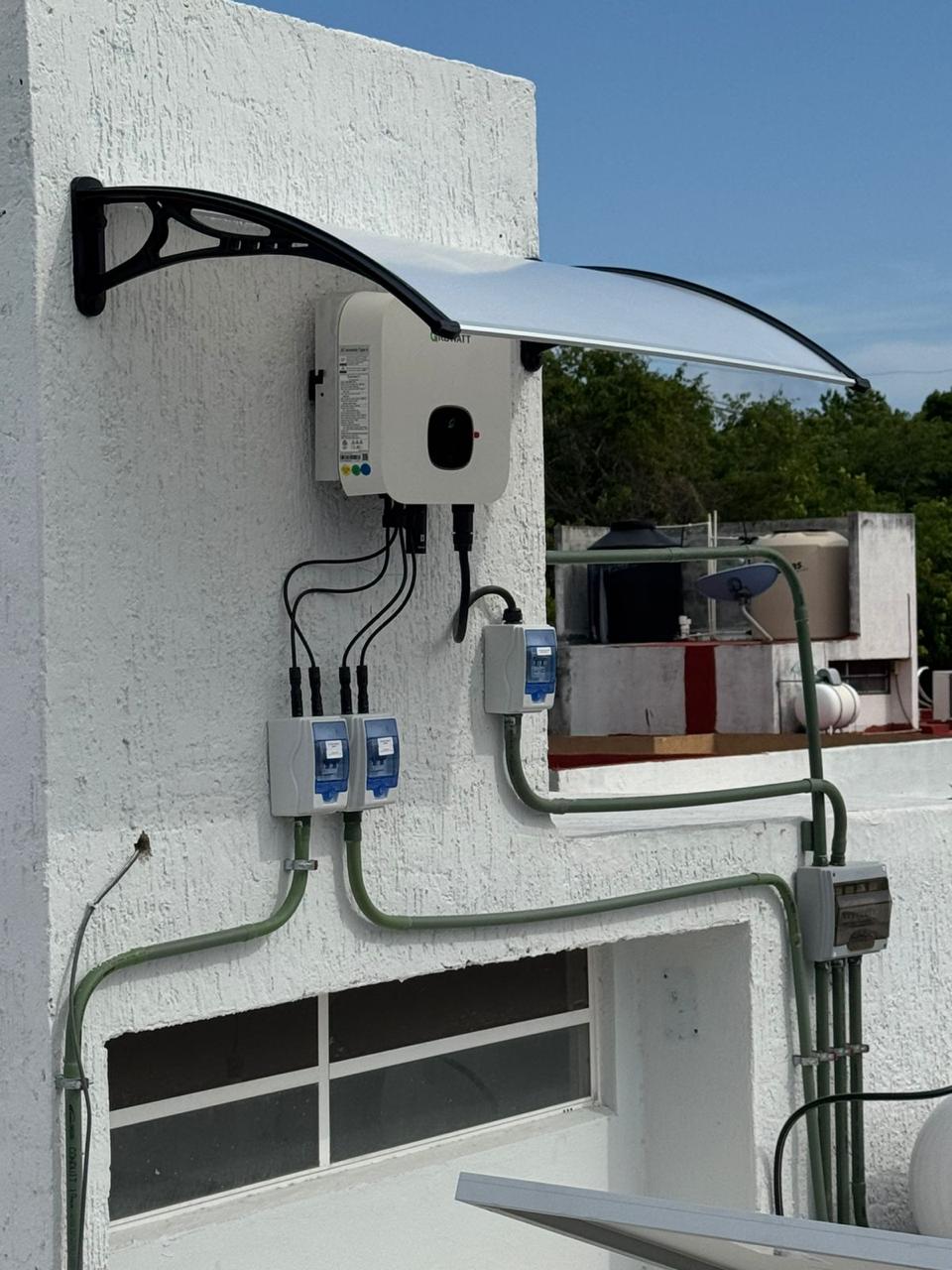 Solar inverter mounted under a protective awning to shade it from direct sun