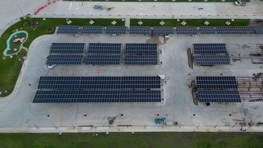 Aerial view of a large solar carport array over a commercial parking area