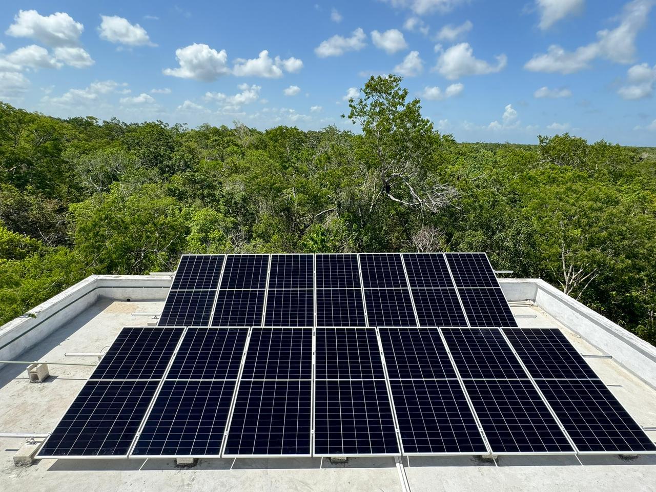 Solar array on a villa rooftop surrounded by Yucatan jungle