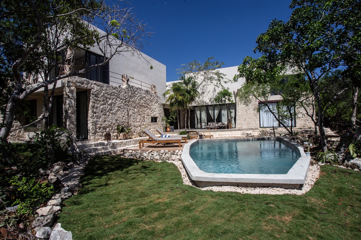 Stone villa with a pool and lawn set in jungle in Akumal