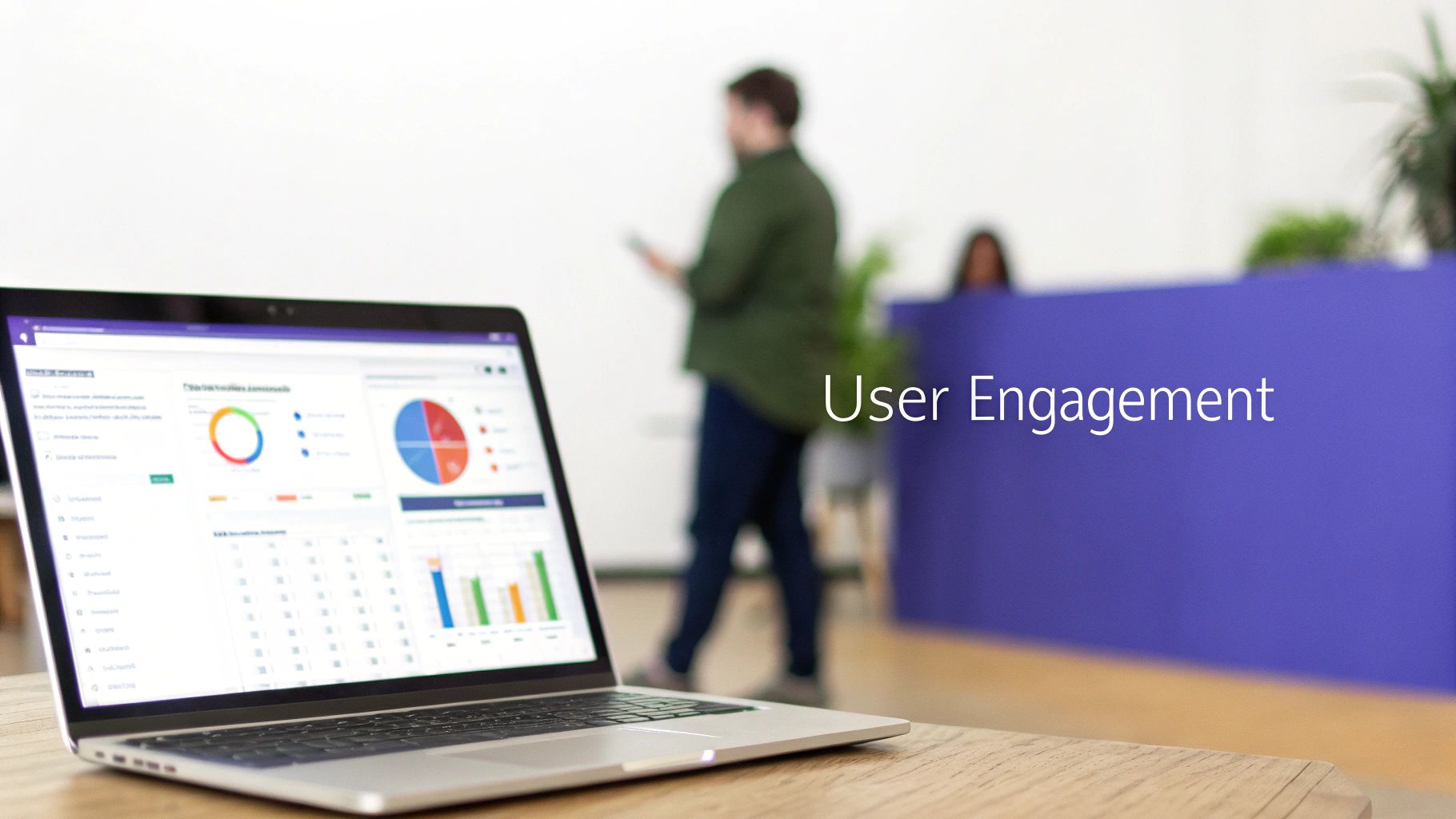 A laptop displays user engagement data and charts in a modern office environment.