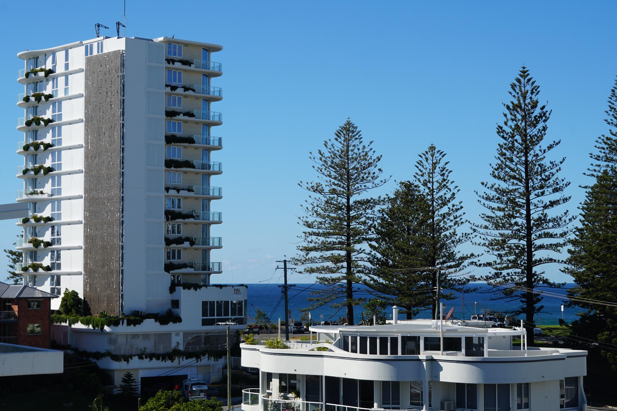 Panoramic beach views from a top-floor Garland apartment balcony