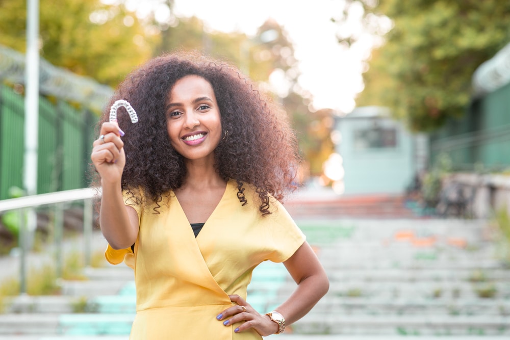 Woman smiling, Can You Eat With Invisalign? blog from Gardner & La Rochelle Orthodontics