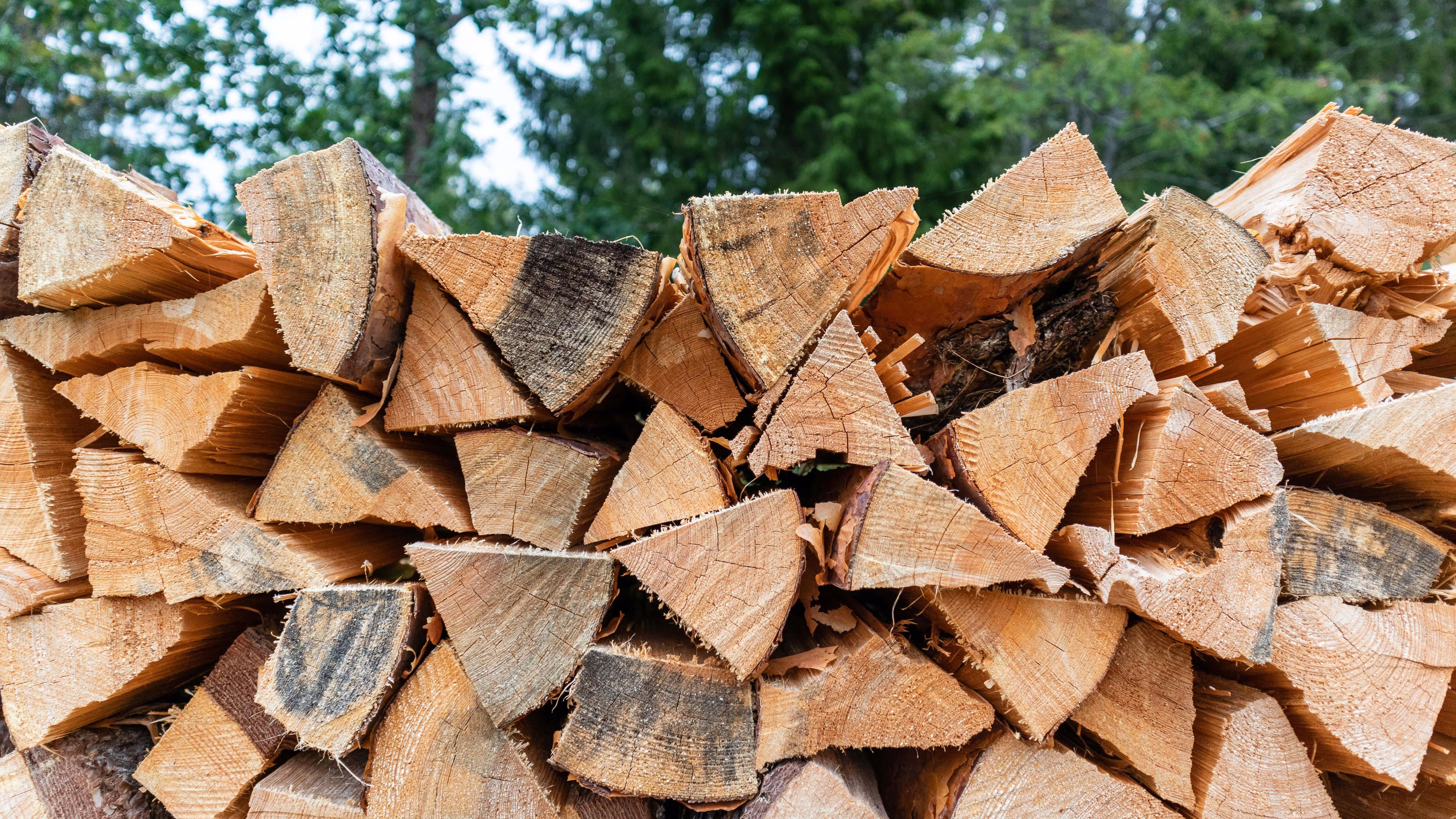 A neatly stacked pile of split firewood.