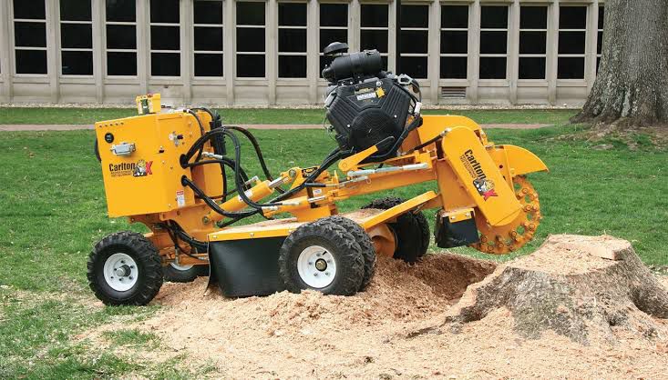 A specialised machine in the process of removing a tree stump.