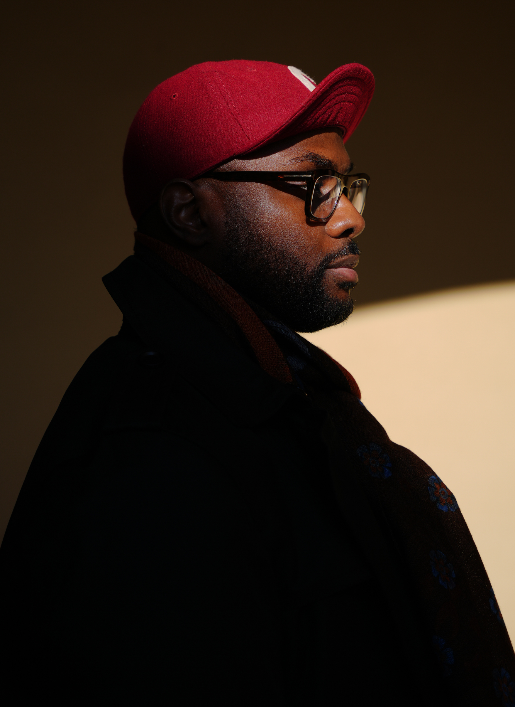 Dramatic profile portrait of Mike Steven François, captured in soft light and shadow for the About Me section.