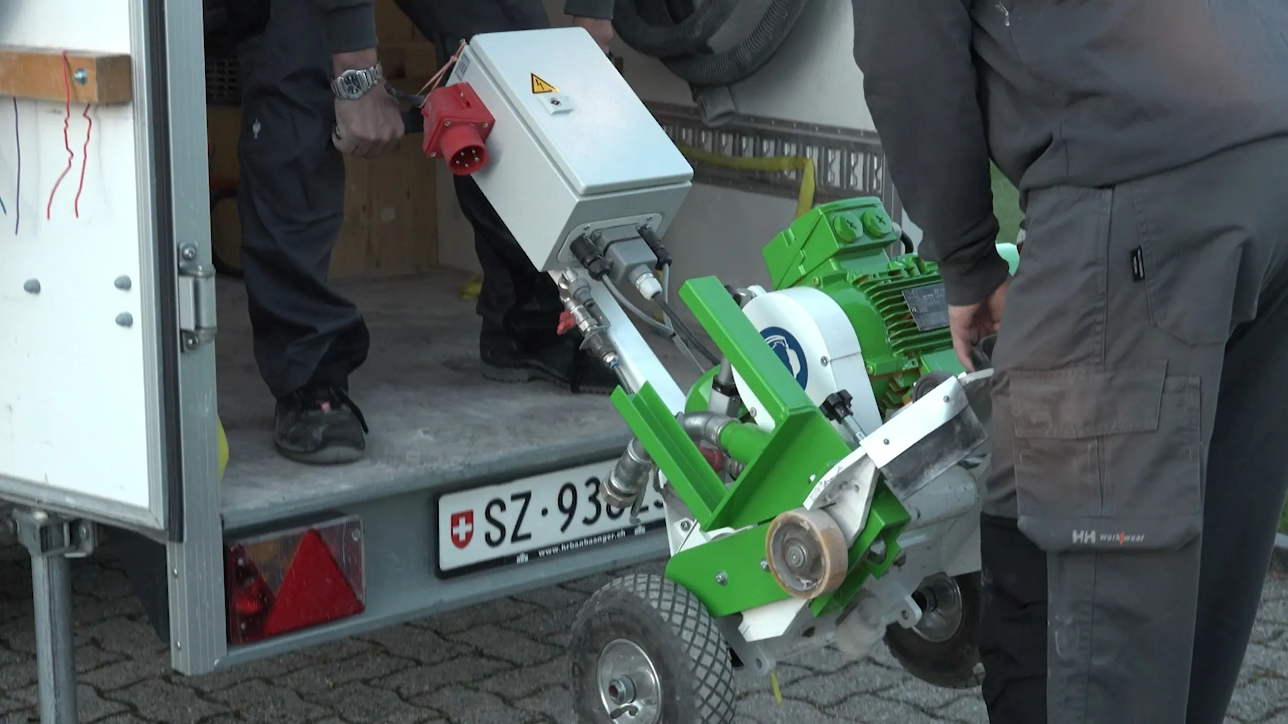 A man standing next to a green machine.