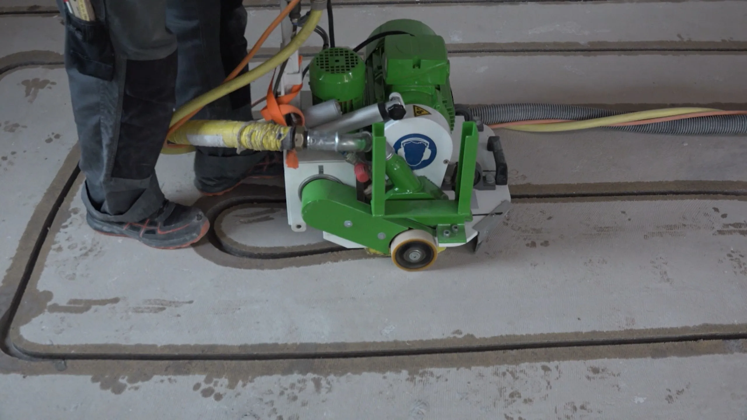 A person standing next to a machine with a hose.