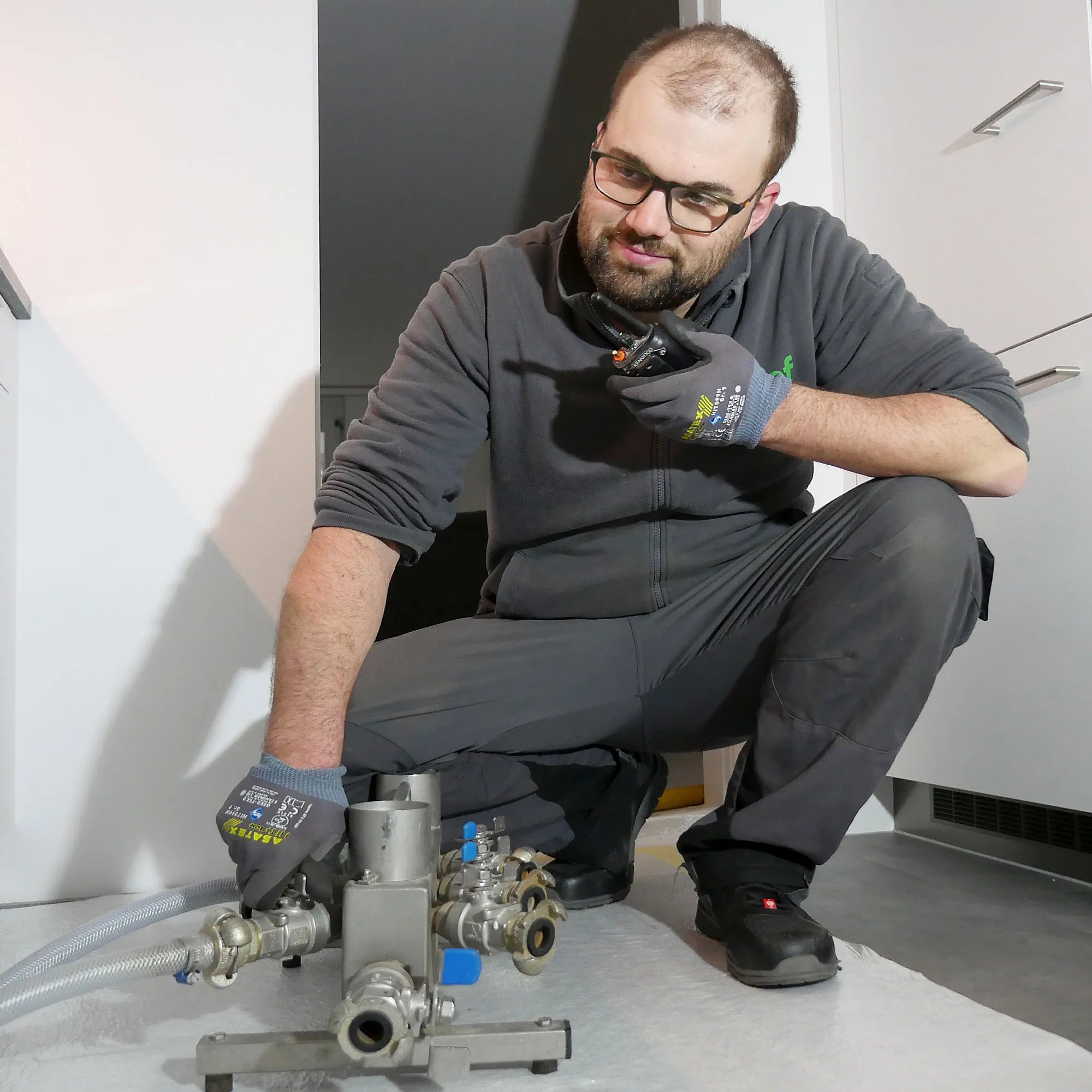A man kneeling down next to a machine.