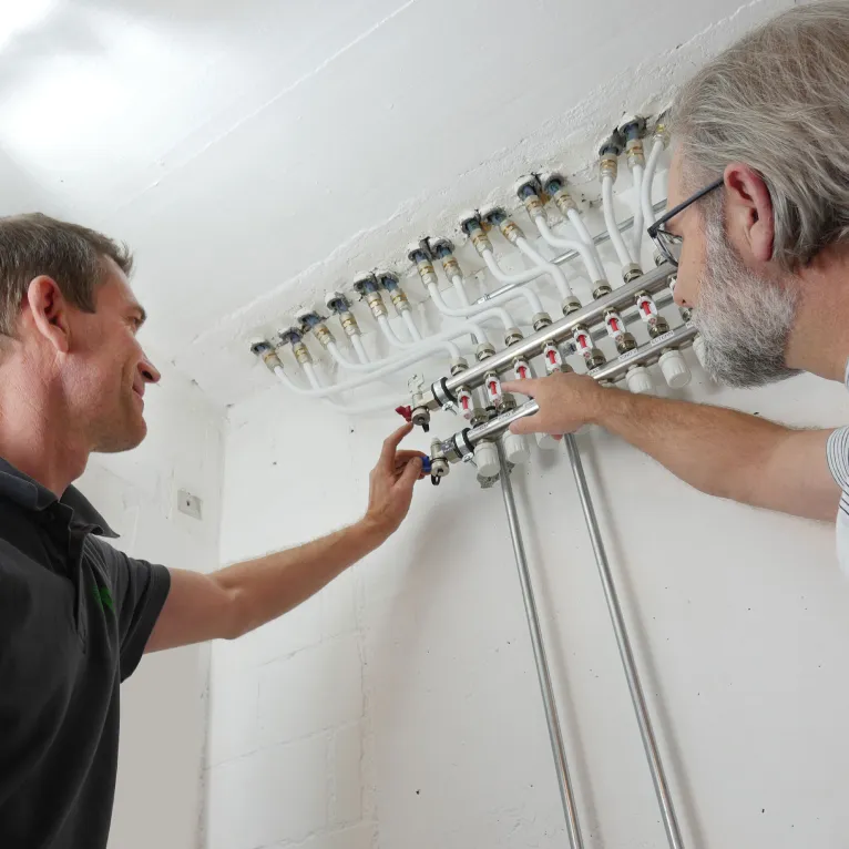 Two men working on an electrical panel.