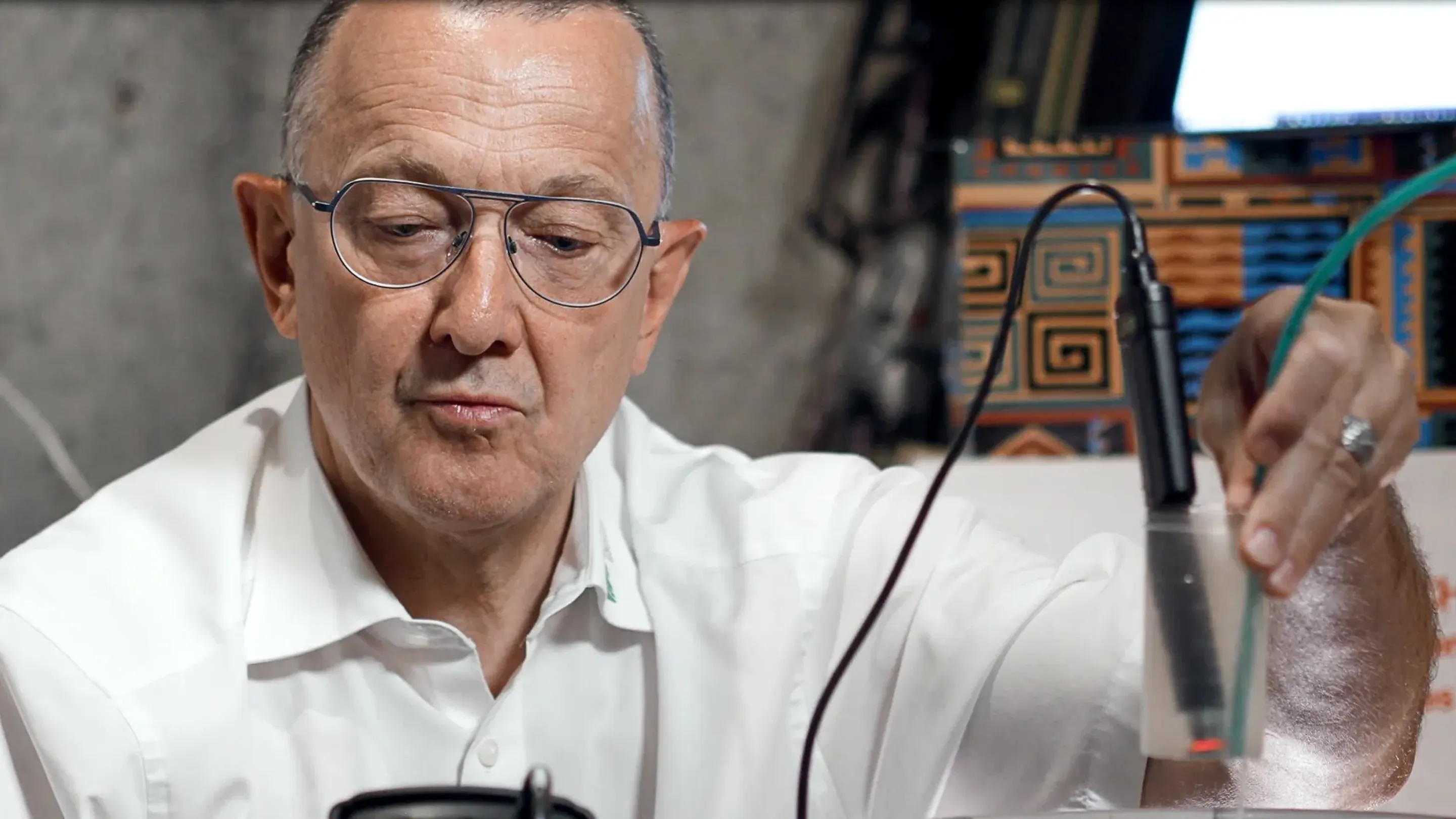 A man in a white shirt holding a microphone.