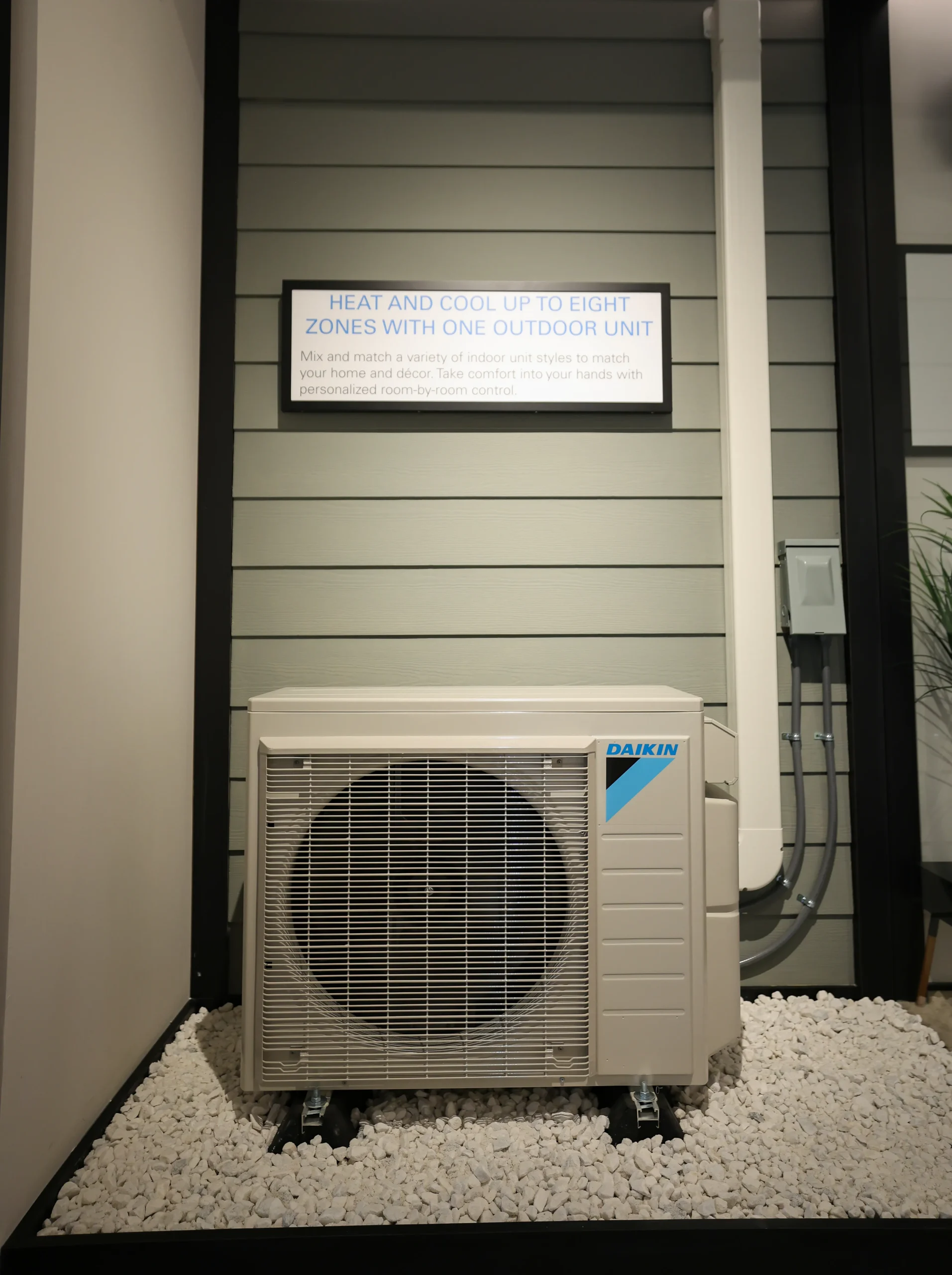 Daikin outdoor air conditioning unit on white stones with information sign
