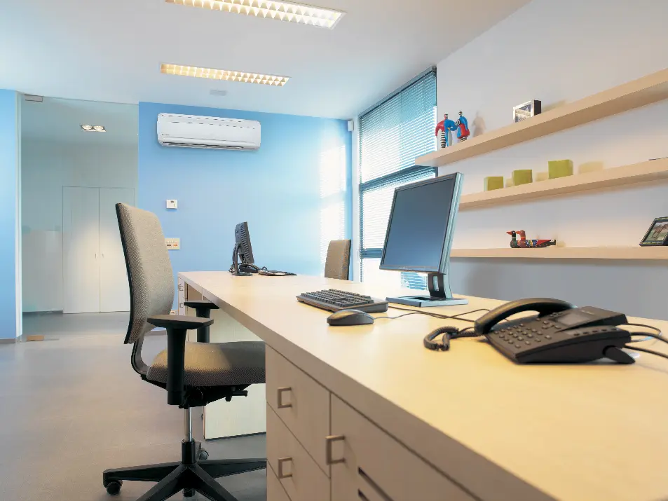 Modern office workspace with computer, desk, and blue wall