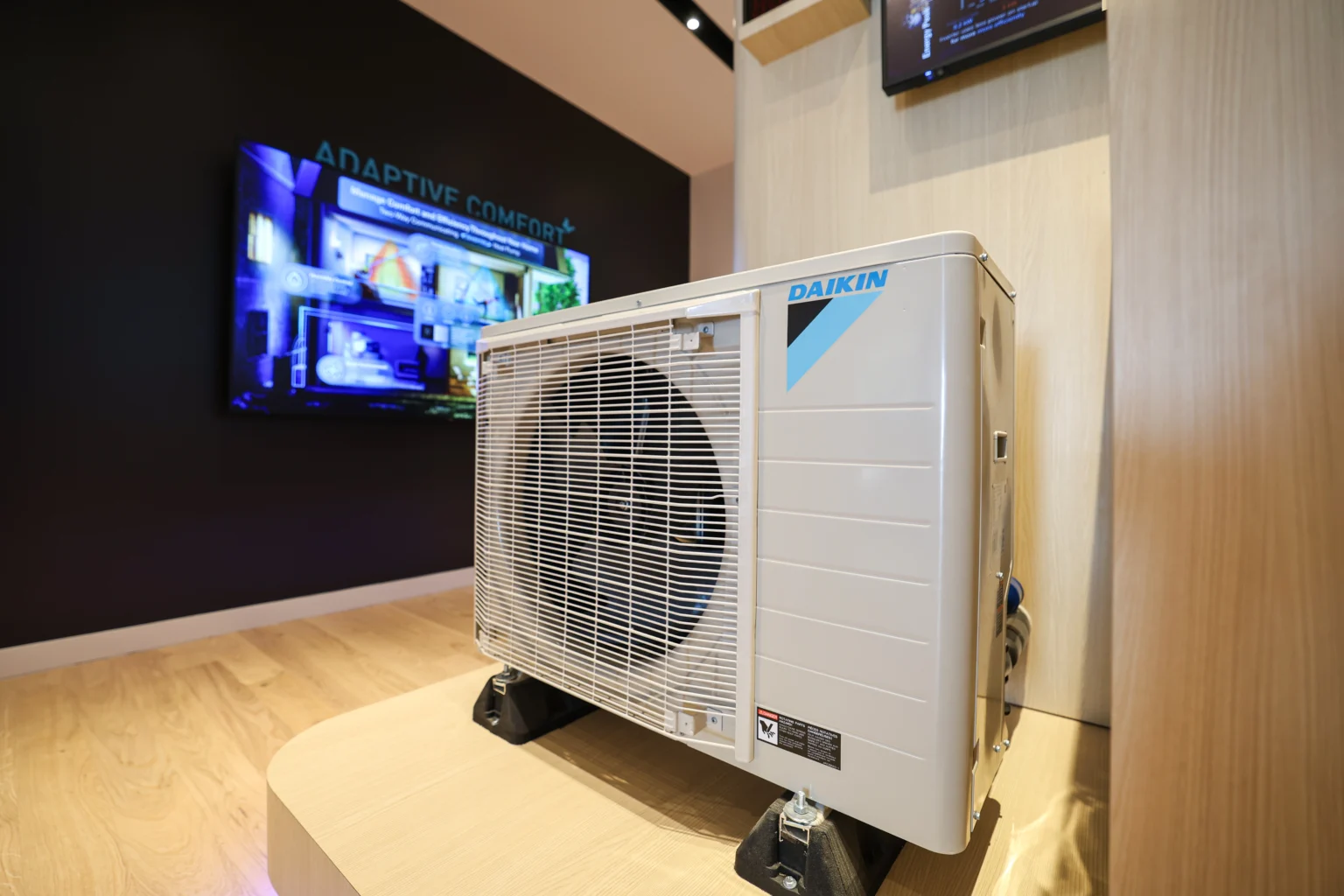 Daikin air conditioning unit displayed on a raised platform with digital screen