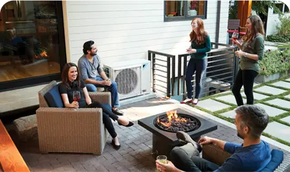 Friends gather around outdoor fire pit on cozy patio with modern furniture