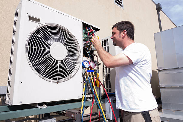 HVAC technician repairing an air conditioning unit with diagnostic tools