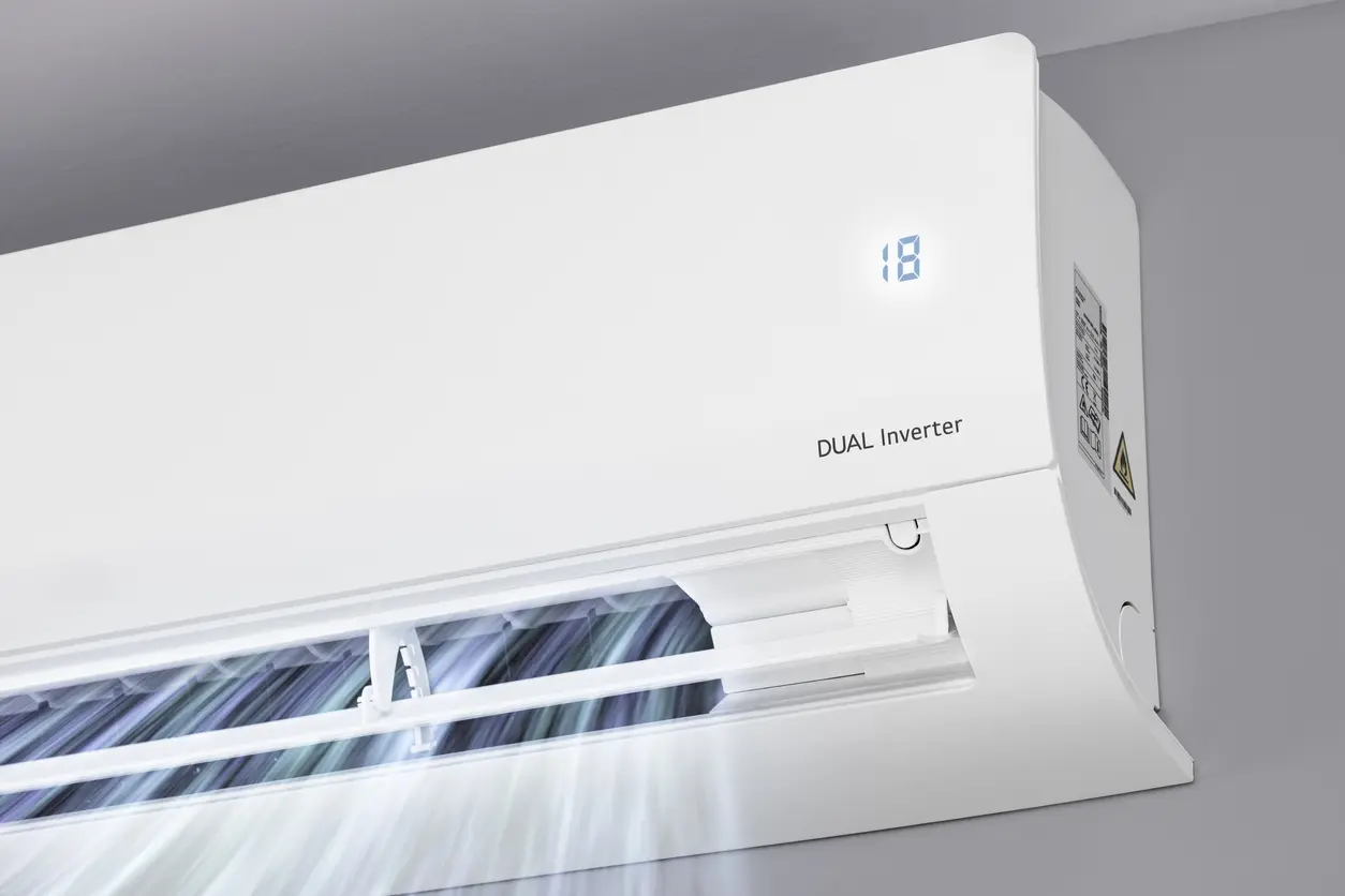 White dual inverter air conditioner with digital display mounted on wall