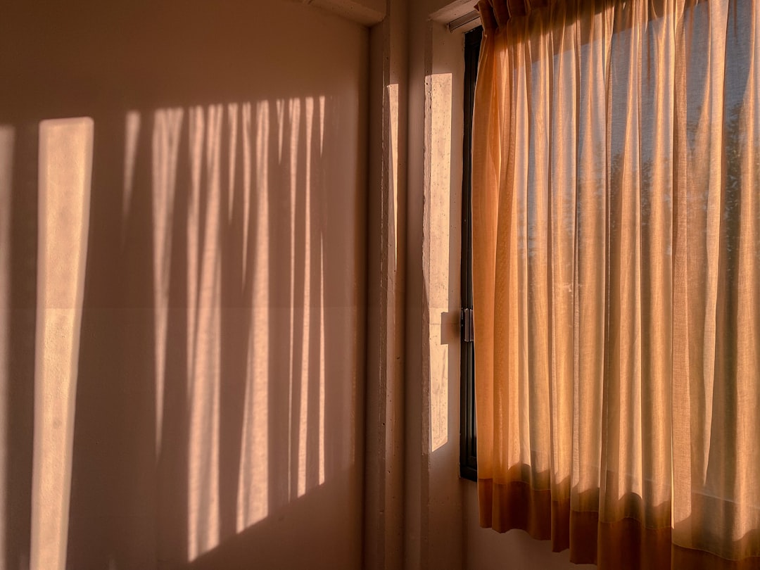 stylish light-colored curtains blocking sunlight from a window - Efficient home cooling