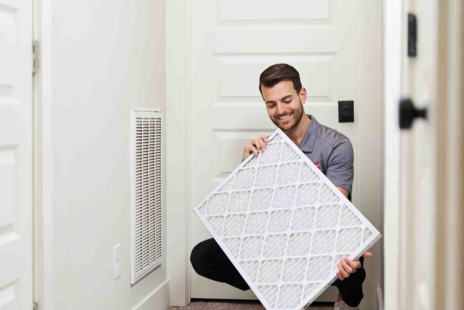 homeowner cleaning the filter of a wall-mounted mini split unit - ductless mini split installation seattle wa homeowner cleaning the filter of a wall-mounted mini split unit - ductless mini split installation seattle wa