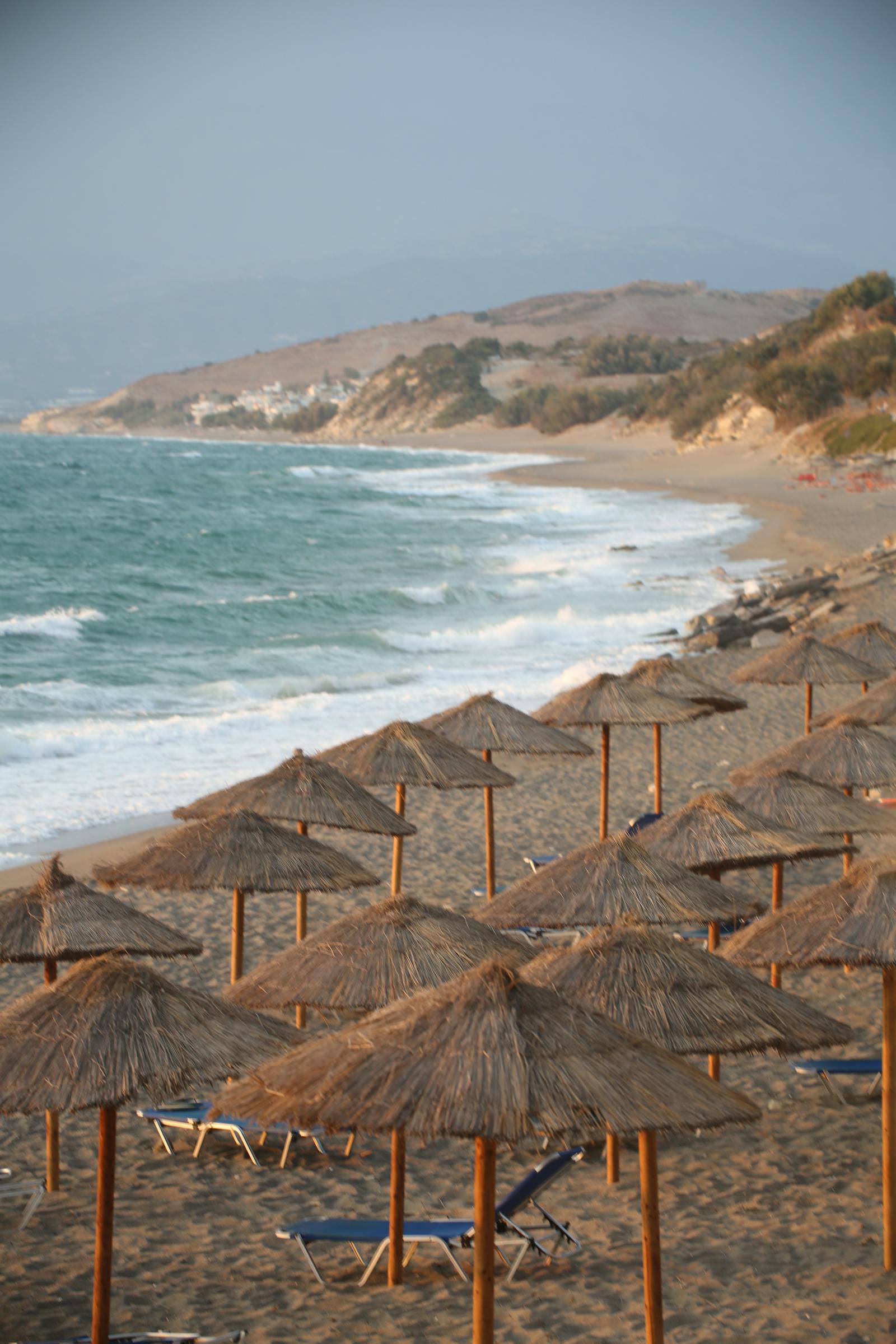 Scenic Mediterranean beach with straw parasols and turquoise water at Coral Bay, Cyprus