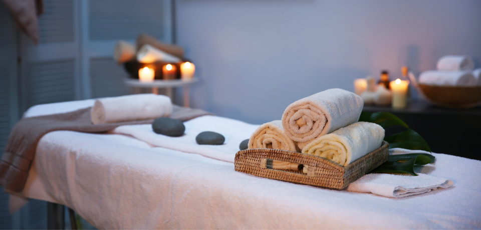 Massage table with folded towels and candles