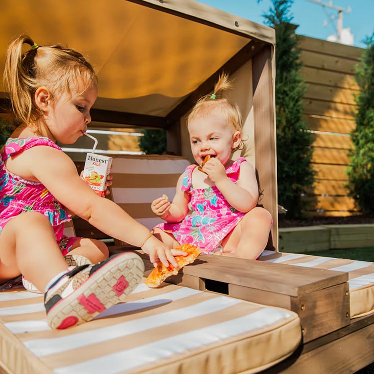 Toddlers enjoying snacks under a cabana at The Yard Ocean City NJ, a family-friendly play destination
