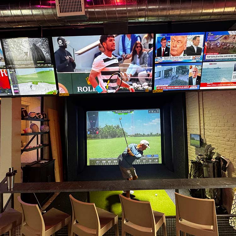 Indoor Full Swing sports simulator with multiple TV screens at The Yard in Ocean City, NJ