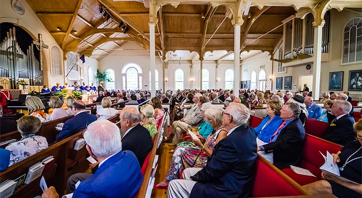Churchgoers seated on wooden pews inside the chapel