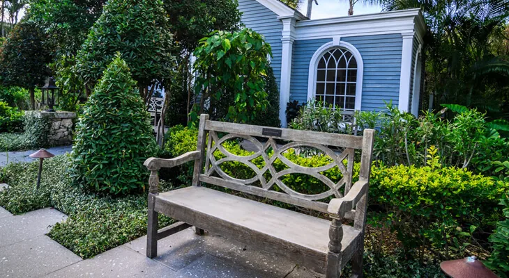 An antique-style wooden bench with ornate details, placed just outside the chapel