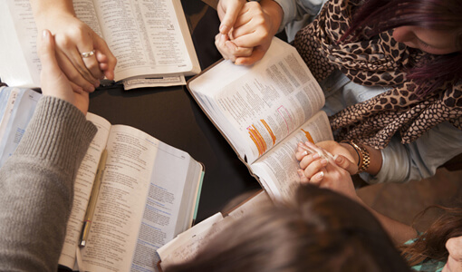 women praying together duing a bible study session