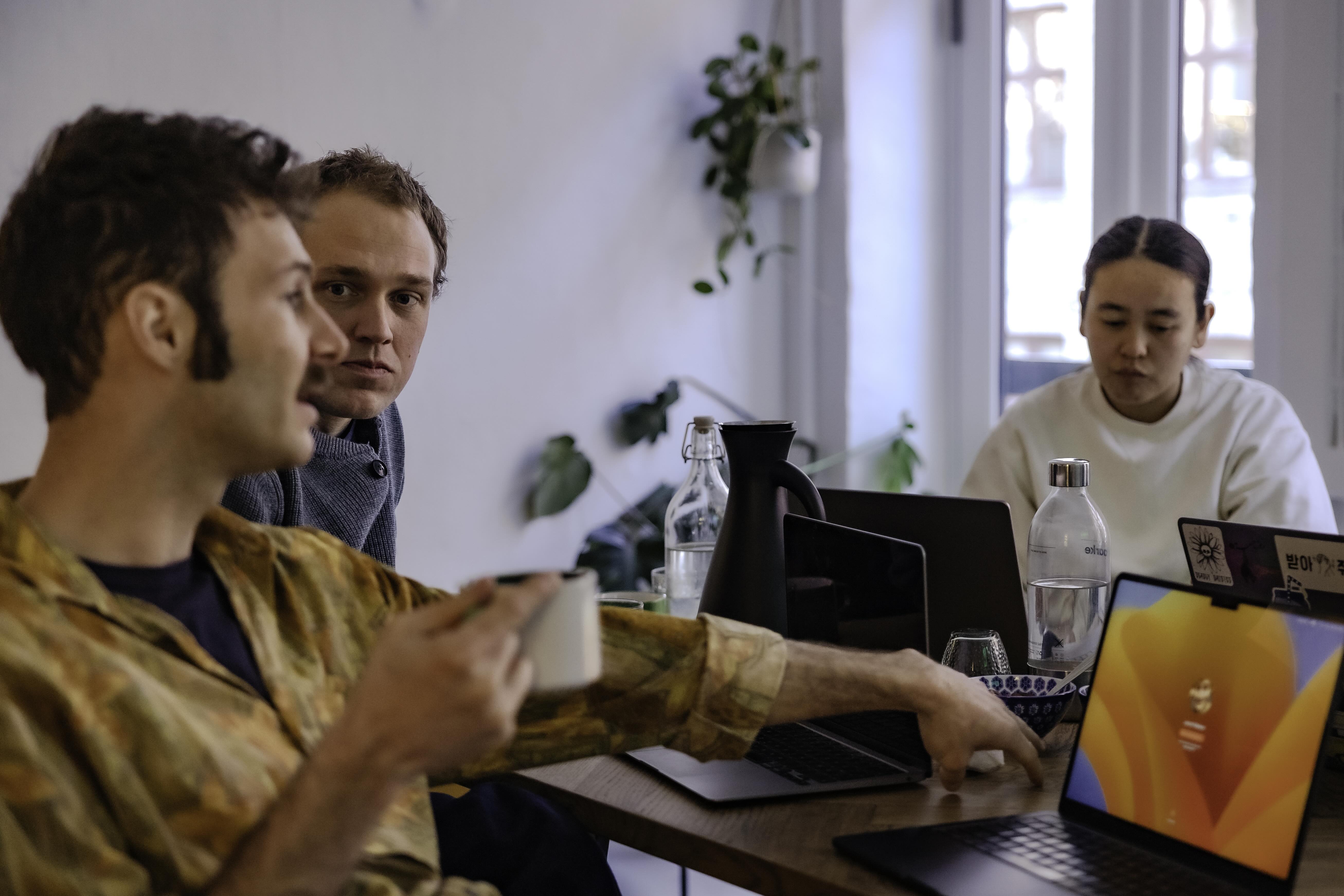 Mand, der drikker kaffe, taler, mens mand og kvinde lytter