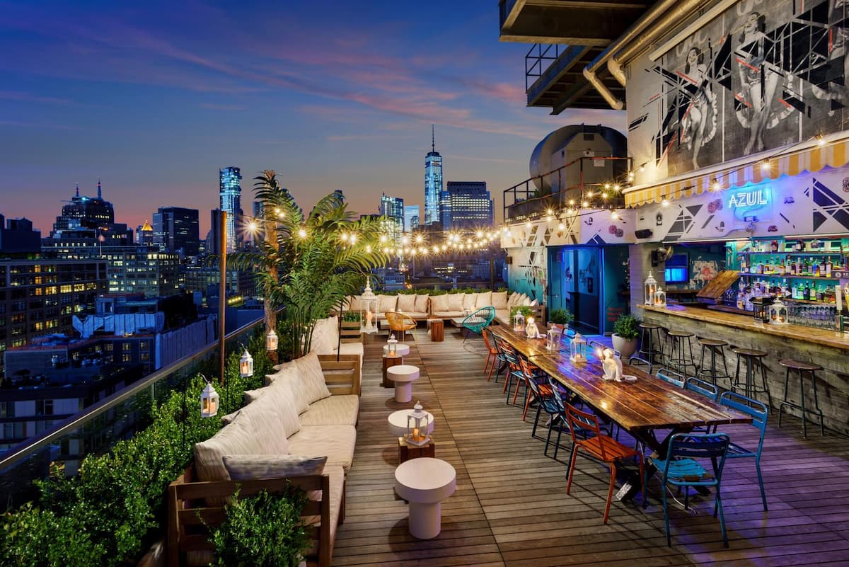 Hotel Hugo NYC rooftop bar with skyline views at sunset.