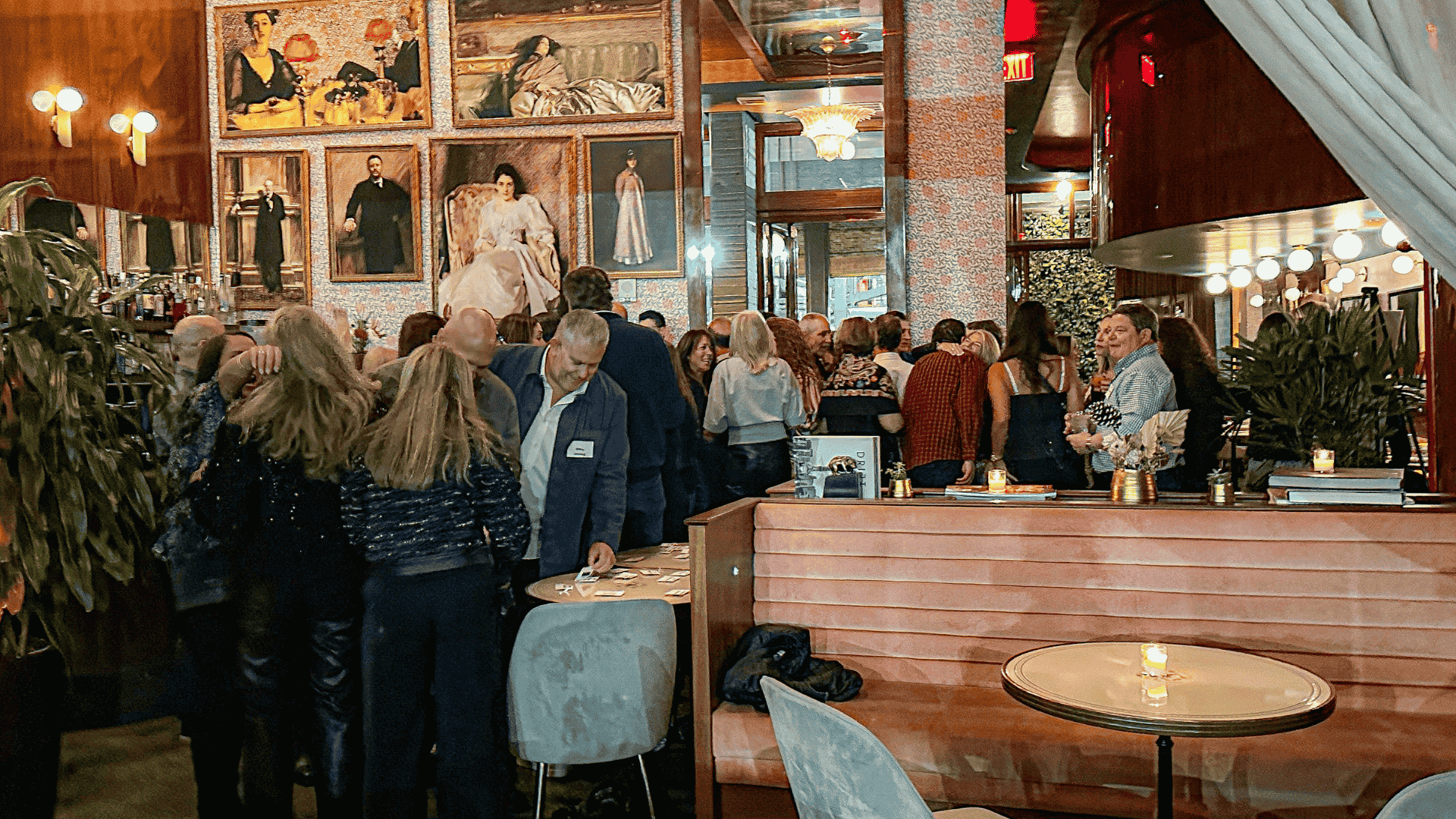 Indoor restaurant/bar with many people standing and sitting