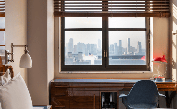 A bright hotel room interior featuring a wooden desk